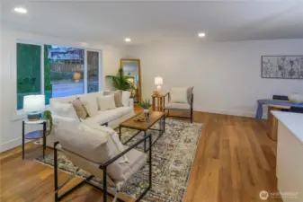 Bright, fully remodeled living room featuring wide-plank flooring, fresh finishes, and an open layout perfect for everyday living and entertaining.
