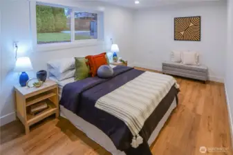 Spacious lower-level bedroom with bright natural light and plenty of room for a full bedroom setup or flexible use.
