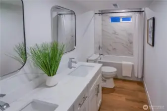Fully remodeled lower-level bathroom featuring all-new fixtures, stylish tile surround, and a clean modern design.