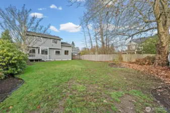 The back of the home features a spacious deck that offers easy access to the interior through the sliding glass door, perfect for seamless indoor-outdoor living. This setup is ideal for entertaining, dining al fresco, or simply enjoying the peaceful surroundings of the private backyard.