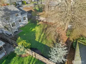 From above, you can appreciate the size of the fully fenced backyard and the connection between the deck and main living areas. The open green space provides endless opportunities for gardening, play, or relaxing under the trees.