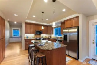 Spacious kitchen featuring granite countertops, durable cabinetry, and a coffered ceiling, creating a stylish and functional gathering space in this Cherry Lane Estates condo.