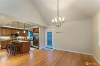 Flexible front living space perfect for a sitting room or dining area, featuring oak hardwood floors. Not exterior door that goes out to the patio and backyard. Photo depicts the room without furniture; seller furnishings are currently in the home.