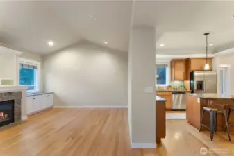 View from the hallway showcasing the open connection between the living room and kitchen, creating a comfortable and functional gathering space. Photo depicts the rooms without furniture; seller furnishings are currently in the home.