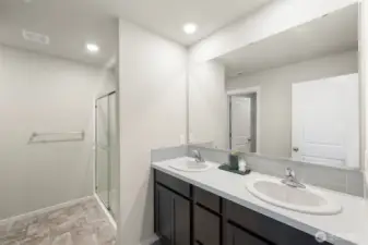 Primary bedroom features a double vanity, walking shower, and huge walk-in closet
