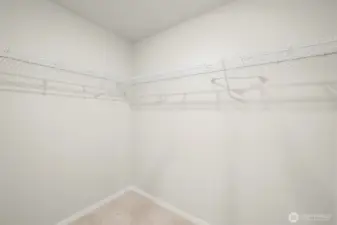 Primary bedroom features a double vanity, walking shower, and huge walk-in closet