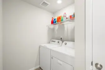 Large upstairs laundry room with overhead storage.