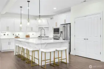 Updated kitchen with large island with sink and Quartz counters, stainless steel appliances and gas cooking.