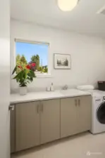 The generous laundry room with full sink, a window and lots of storage.