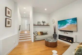 Open living room with gas burning fireplace. Powder room is to the right of the front door.