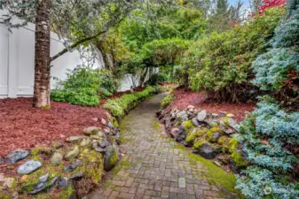 Mature landscaping and stone walkway lead from the patio...