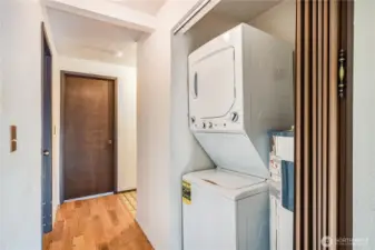 The stackable washer and dryer stay with the home, and can be hidden behind the accordion door of this closet.