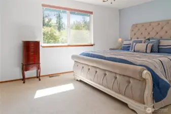 The primary suite is a serene retreat, featuring a thoughtfully designed vanity and sink in the bedroom, a private bath, and abundant natural light that creates a warm, relaxing atmosphere.
