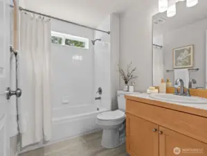 On the opposite side of the kitchen is a full bathroom. Conveniently located.