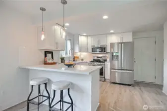 Enjoy the updated kitchen with quartz countertops, SS appliances (gas stove) and bar seating.