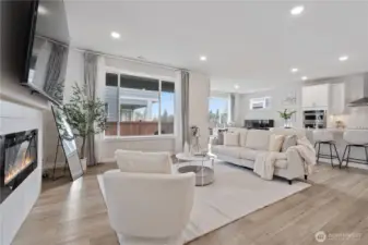 Sun-drenched open-concept living space where soaring windows meet modern comfort, creating an inviting heart of the home.