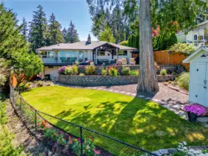 Gently sloping yard is manicured and lovely.