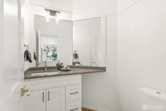 The guest ½ bath has been updated with a new vanity with quartz counter and new lighting.