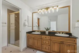 Primary bathroom with large soaking tub, maple vanity, granite counter and separate shower area.