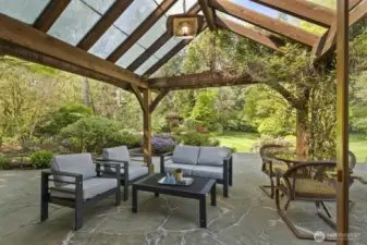 Pennsylvania blue stone patio off the kitchen features a clear, vaulted ceiling allowing for natural light, water feature, outdoor lighting, a gazebo and a garden shed.