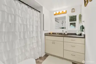 New cabinets and counters in bathroom, built in shelf, and window.