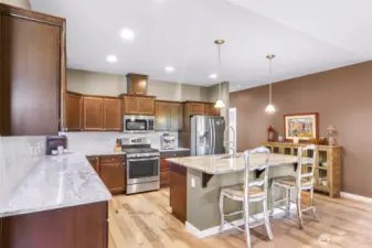 Spacious kitchen with plenty of storage and counter space, tons of storage. View from dining space thru kitchen to hallway to main level bedrooms, guest bath and utility room