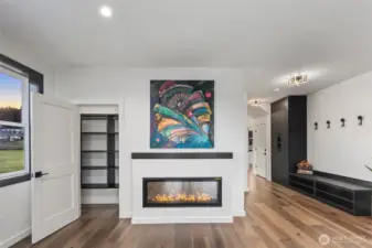 Spacious great room with storage & electric fireplace.