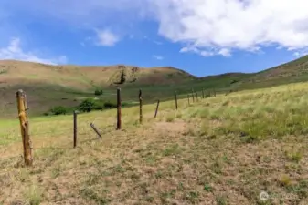 Follow the fence and follow your heart to many beautiful camp or building sites on this property.