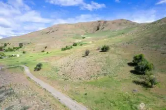 Simple dirt gravel driveway takes you on the property and shared with neighbor beyond the 7.33 Acres to the East.