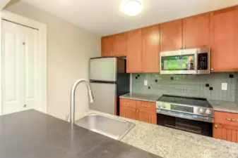 Attractive tile backsplash & granite countertops.  Cherry stained maple cabinetry is featured thruout the condo.