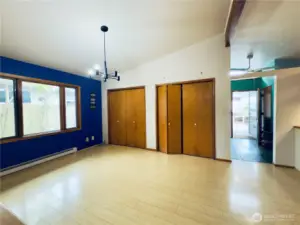 Dining room area, natural light, built-in shelving, two storage closets the length of the room, views to side yard, entryway, kitchen with bar seating