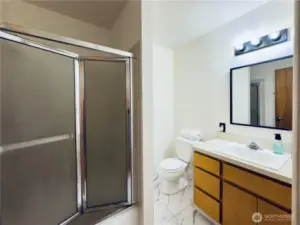Main bathroom with tub, shower, toilet, vanity and sink. New flooring