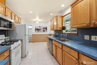The kitchen is a cook’s dream, featuring beautiful cabinetry with stylish hardware and a sleek stainless-steel farm sink perfectly positioned beneath a large, light-filled window. All appliances are included, including a new dishwasher.