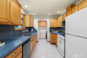 The kitchen is a true centerpiece, featuring a new stainless-steel farm sink, new stainless-steel dishwasher, gas range oven, garbage disposal, and stainless-steel microwave. On one side, a bright kitchen nook offers the perfect spot for casual dining, while on the other side, the laundry room provides convenience and functionality. A large walk-in pantry keeps everything organized, and a door leads directly to the huge, marvelous backyard, seamlessly connecting indoor and outdoor living.