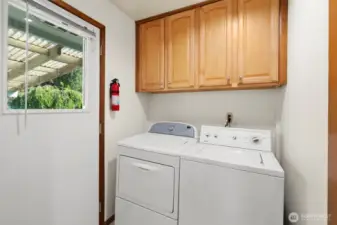 A Laundry room with washer/dryer, walk-in pantry & a glass door opens to the yard, allowing you to extend your entertainment outdoors perfect for hosting gatherings and enjoying the fresh air. Entertain in style in this cozy kitchen and living space, complemented by a thoughtful floor plan designed for both comfort and functionality, seamlessly connecting indoor and outdoor living.