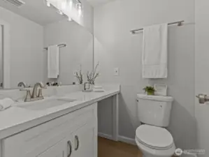 The other side of the bathroom has an oversized vanity with open space underneath for extra storage.