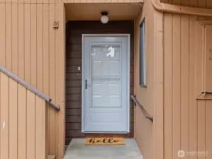 A covered front porch has a cubby to the left.