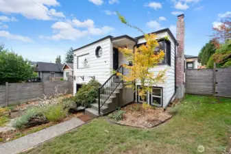 Charming updated exterior featuring crisp white siding with black trim, a welcoming front entry, and mature landscaping. Perfect blend of classic design and curb appeal