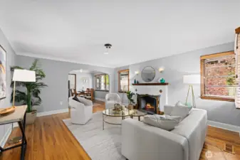 Spacious living room anchored by a stylish tiled fireplace and gleaming hardwood floors. Neutral tones and classic details create an inviting space for relaxing or entertaining.