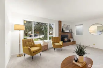 Bright living space with large windows and cozy fireplace.
