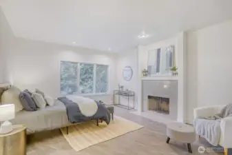 Primary suite with large open space and a wood burning fireplace.