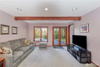 Family room looking towards front of home, wood deck area. Beautiful wood french doors.