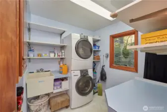 Laundry room with sink, shelving and counterspace.