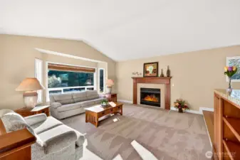 The main level living room delivers the comfort buyers want, vaulted ceiling volume, wide wall space, and a centerpiece fireplace for cozy evenings. Natural light pours in through a large picture window, keeping the room bright through every season. The split level design gives the living area a distinct, relaxing feel while still connecting to the rest of the home.