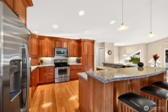 The kitchen is designed for function, with extensive cherry cabinetry, granite counters, and an oversized island that delivers standout prep space and serving room. Stainless appliances, recessed lighting, and a smart work triangle support everything from quick breakfasts to full holiday cooking.