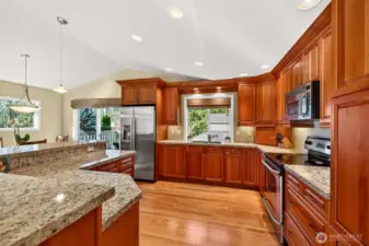 A closer look at the kitchen’s scale, granite surfaces stretch across multiple work areas, paired with ample cherry cabinetry for cookware, pantry items, and small appliances. The island creates a natural landing spot for casual meals, homework, and serving lines when friends are over.