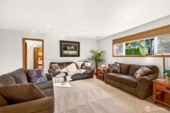 Another view of the lower level shows how flexible the room is, with ample space for multiple uses, media, hobbies, fitness, or a work from home zone. The long window brings in natural light while maintaining privacy.