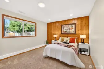 A comfortable bedroom with great natural light, clean trim, and a warm wood accent wall that adds character without sacrificing versatility. The room offers an easy layout for a variety of uses, guest space, office, or hobby room, with a quiet, private feel. Adjacent 3/4 add flexibility of use for long term guests.