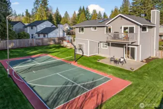 An overhead look at the backyard shows how well the outdoor spaces are organized, sports court, lawn, patio, and deck all working together. Mature evergreens beyond the fence line add a calm, established feel that buyers consistently value on English Hill.