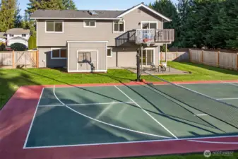 A true backyard lifestyle setup, featuring a multi use sports court for basketball, pickleball, and practice sessions, surrounded by a level lawn and full fencing for privacy.